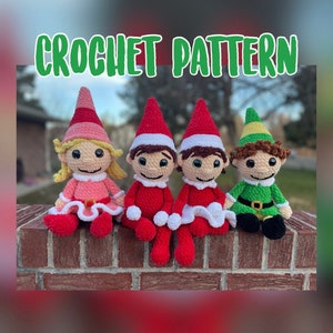 Op de afbeelding: Vier gehaakte elfpoppen die op een bakstenen muur zitten. De poppen dragen rode, roze en groene kleding. De poppen hebben bruin en blond haar. De poppen lachen allemaal. De afbeelding heeft de tekst "CROCHET PATTERN" bovenaan.