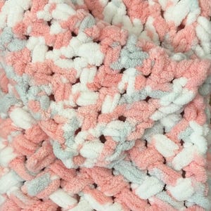 May include: A soft, pink, white, and gray knitted blanket with a fuzzy texture.