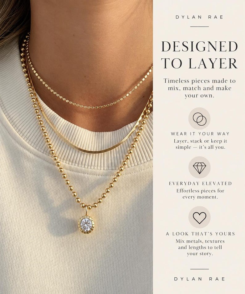 May include: Three gold-toned necklaces layered together. The top is a delicate chain, the middle is a flat snake chain, and the bottom is a beaded chain with a round pendant featuring a clear stone. Text reads: DYLAN RAE DESIGNED TO LAYER.