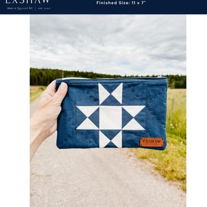 Puede incluir: Una bolsa Ohio Star azul marino con un dise&ntilde;o de estrella blanca. La bolsa est&aacute; acolchada y tiene cierre de cremallera. Tama&ntilde;o final: 28 x 18 cm. La marca EXSHAW es visible en la bolsa y en una etiqueta de cuero.