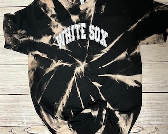 May include: Black tie-dye t-shirt with white "WHITE SOX" text.