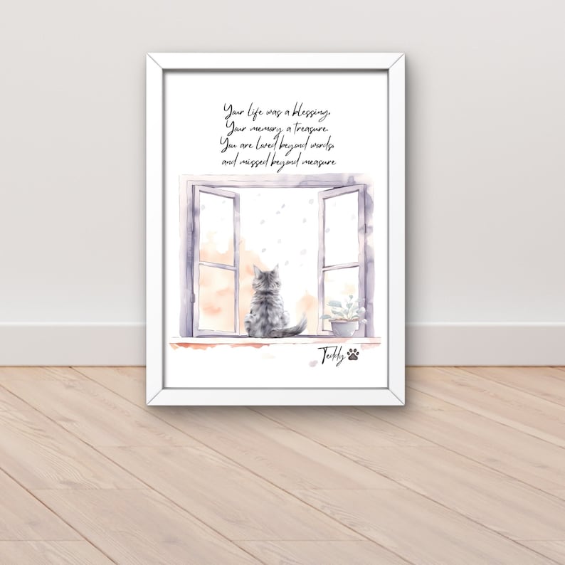Puede incluir: Una impresi&oacute;n enmarcada en blanco con una ilustraci&oacute;n de acuarela de un gato mirando por una ventana. La impresi&oacute;n tiene el texto "Your life was a blessing. Your memory a treasure. You are loved beyond words and missed beyond measure." y el nombre "Tolly" con una huella de pata.