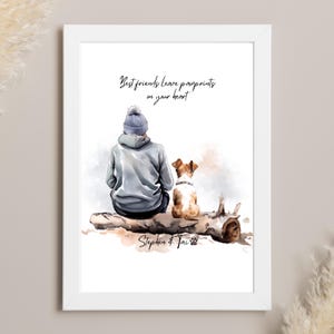 May include: A watercolour illustration of a person and a dog sitting on a log. The person is wearing a grey hoodie and a blue beanie. The dog is brown and white. The text "Best friends leave pawprints on your heart" is written above the image. The text "Stephen & Tai" is written below the image.