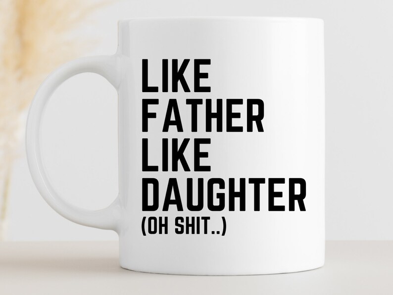 May include: White ceramic coffee mug with black text that reads "Like Father Like Daughter (Oh Shit...)"