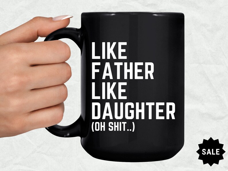 May include: Black coffee mug with white text that reads "Like Father Like Daughter (Oh Shit..)"