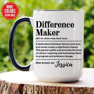 May include: White ceramic mug with a black handle and black text that reads "Difference Maker (dif-er-uhns-mey-ker) noun. A dedicated individual whose small acts and words create a significant impact. This person uplifts and enriches the lives of others, inspiring and motivating them to progress and embrace change. Also known as: Jessica"