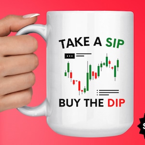 May include: White ceramic mug with a black and green graphic of a stock market chart and the text "TAKE A SIP BUY THE DIP".