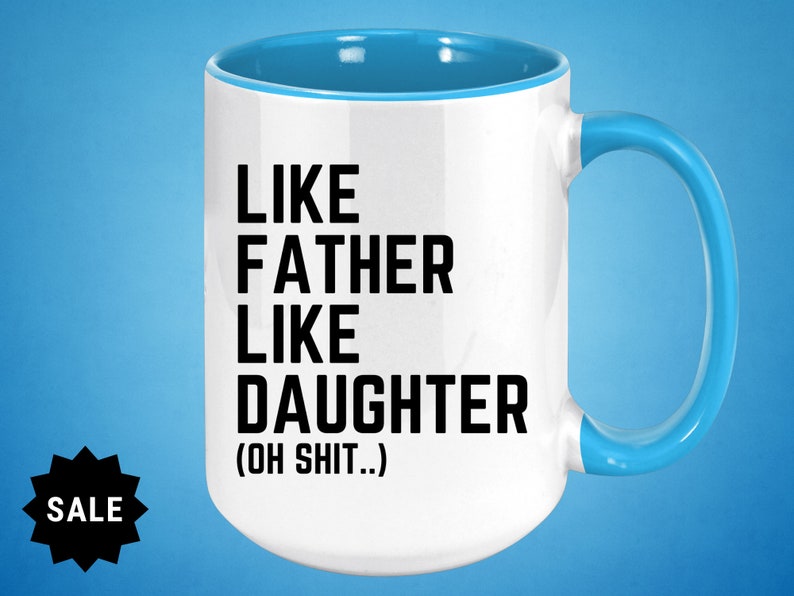 May include: White ceramic coffee mug with a blue rim and handle. The mug has black text that reads "Like Father Like Daughter (Oh Shit...)"