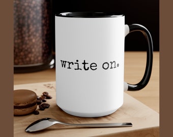 May include: White ceramic coffee mug with a black rim and handle. The mug has the text "write on." printed in black.