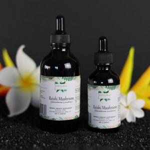May include: Two glass bottles with droppers filled with a dark liquid. The bottles are labeled "Reishi Mushroom (Ganoderma Lucidum)" and are on a black surface with yellow and white flowers.