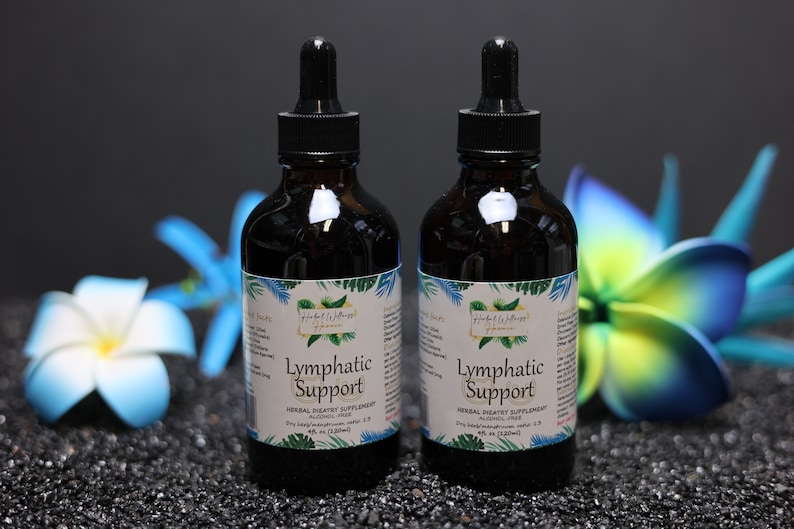 May include: Two brown glass bottles with droppers, labelled "Lymphatic Support" and "Herbal Dietary Supplement, Alcohol Free". The bottles are on a black surface with blue and white flowers.