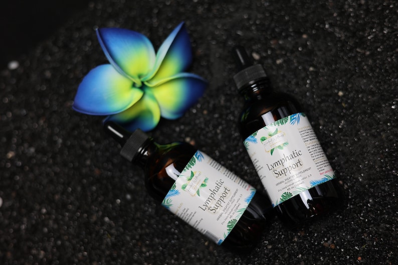 May include: Two brown glass bottles with droppers, labelled "Lymphatic Support" on a black background. The bottles are surrounded by a blue and yellow flower.