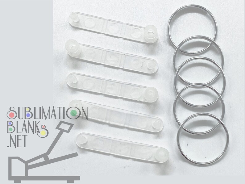 Puede incluir: Un conjunto de plantillas de sublimaci&oacute;n de pl&aacute;stico transparente y llaveros de metal plateado. Las plantillas de pl&aacute;stico son rectangulares con extremos redondeados y peque&ntilde;as protuberancias circulares. Los llaveros son circulares y de metal brillante. El texto "SUBLIMATION BLANKS .NET" est&aacute; presente.