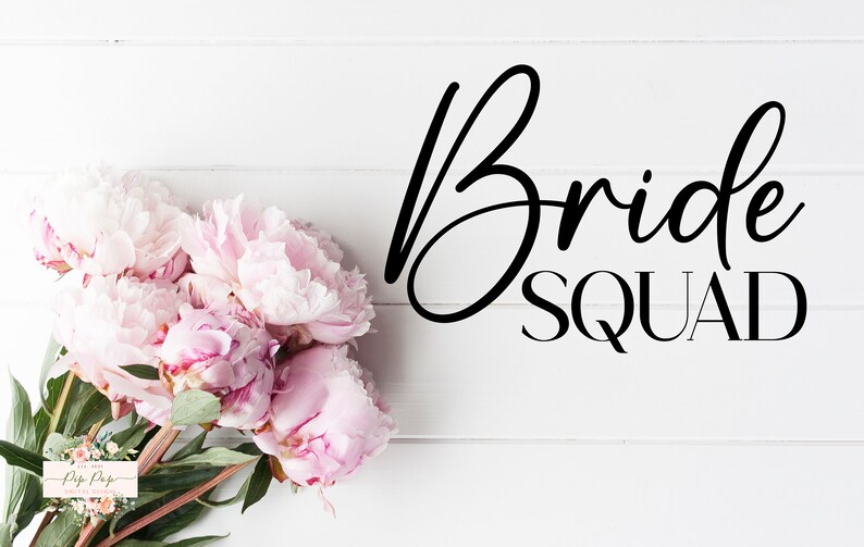 Op de afbeelding: Een boeket roze pioenrozen met groene bladeren op een wit houten oppervlak. De woorden "Bride SQUAD" zijn in zwart schrift geschreven. Thema: bruiloft of bruidsfeest.