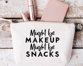 May include: White canvas makeup bag with a black zipper and the text "Might be makeup Might be snacks".