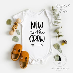 May include: White baby onesie with black text that reads "New to the Crew" with a black arrow pointing to the right.