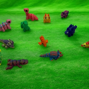 May include: A collection of ten colorful dinosaur figurines, each with unique details and textures. The dinosaurs are arranged on a green grassy surface.