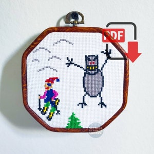 May include: Cross stitch pattern featuring a skier and a monster in a snowy landscape. The pattern is framed in a wooden octagon frame. The pattern is available as a PDF download.