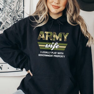 May include: Black hooded sweatshirt with a camouflage print design that says "Army wife I legally play with government property".