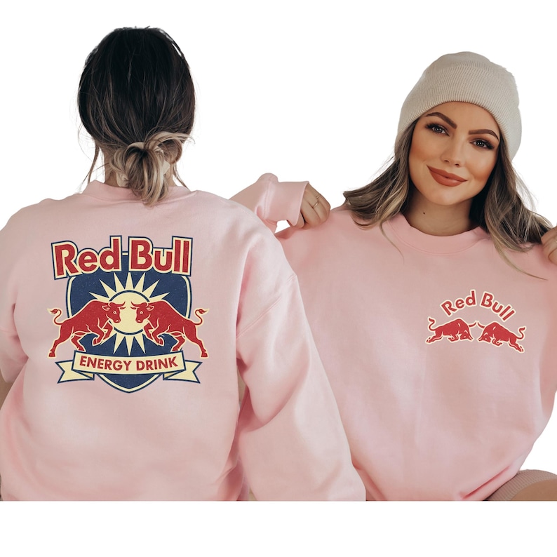 Two women wearing matching pink sweatshirts with the Red Bull logo.