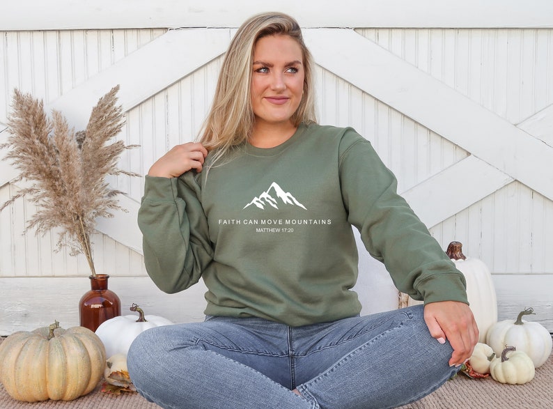 May include: A green sweatshirt with a white mountain graphic and the text "Faith can move mountains Matthew 17:20".