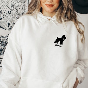 May include: White hoodie with a black silhouette of a Schnauzer dog and the text "Boomer" on the front.