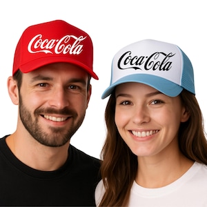 May include: Two trucker hats with the Coca-Cola logo. One hat is red with a white logo, and the other is white and light blue with a black logo. The hats have a mesh back.