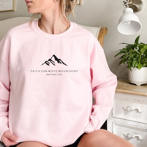 May include: Pink sweatshirt with a black mountain graphic and the text "Faith can move mountains Matthew 17:20"
