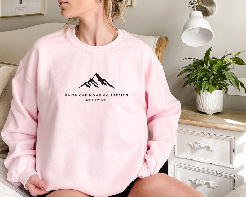 May include: Pink sweatshirt with a black mountain graphic and the text "Faith can move mountains Matthew 17:20"