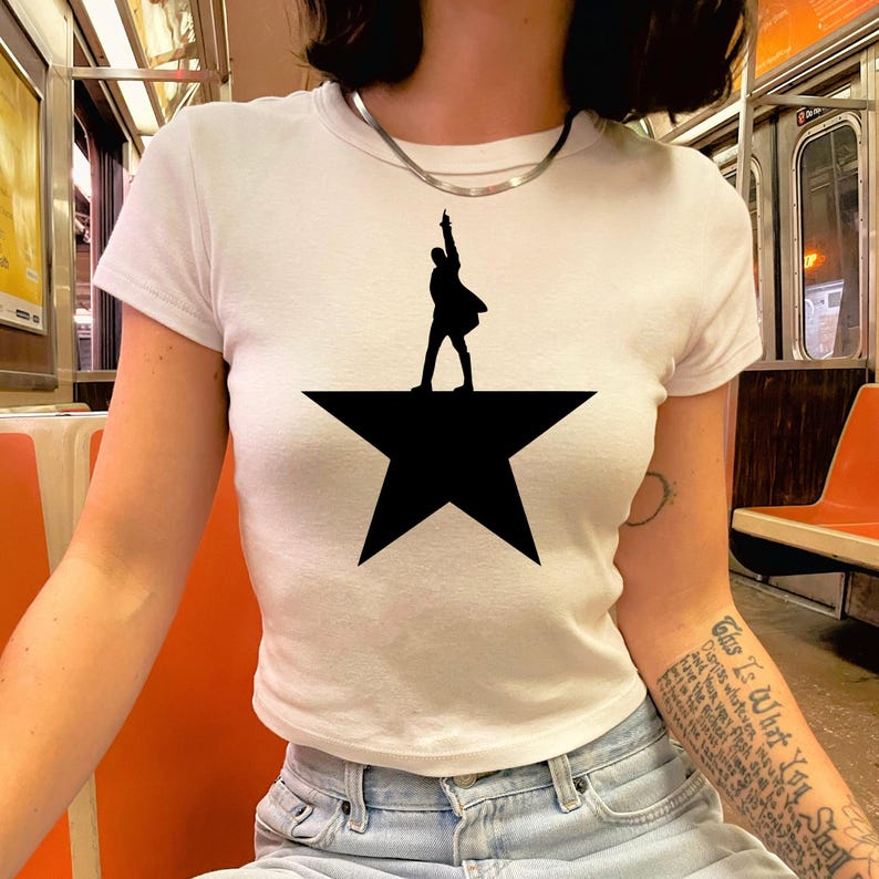 A person wearing a white t-shirt with a black silhouette of a person standing on a star.