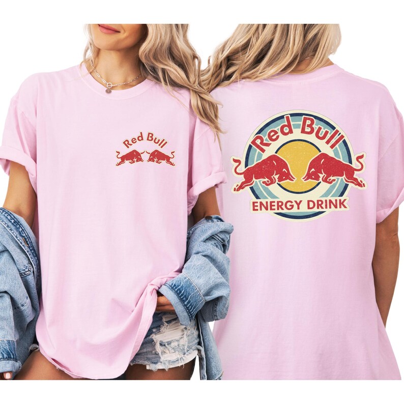 A woman wearing a pink t-shirt with the Red Bull logo and the text "Red Bull Energy Drink" printed on it.