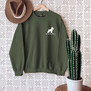 May include: A green sweatshirt with a white silhouette of a Schnauzer dog and the text "Custom Dog Name".