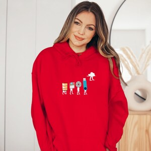 May include: A red hoodie with a graphic of a line of people carrying different types of storage devices, including a floppy disk, a CD, a USB drive, and a cloud. The graphic is in the center of the hoodie.
