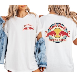 two women wearing white t-shirts with the Red Bull logo and the text "Red Bull Energy Drink" printed on them.