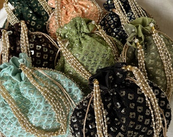 May include: A collection of six drawstring bags with beaded tassels. The bags are made of a soft fabric and are decorated with sequins and embroidery. The bags are available in a variety of colors, including green, black, and peach.