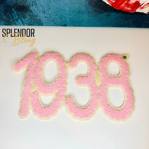 May include: Pink felt applique of the year 1938. The numbers are outlined in a cream color.