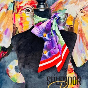 May include: A colorful silk scarf with a floral pattern, featuring purple, white, and green flowers. The scarf has red and white stripes on the edges and is displayed on a black mannequin. The background features an abstract painting.