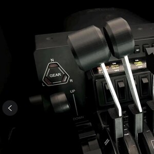 May include: Black flight simulator throttle quadrant with levers, switches, and dials. The image shows a close-up of the control panel with the text "GEAR" and "UP" and "DOWN" labels. The text "*BRAVO THROTTLE NOT INCLUDED" and "IDIGFLIGHTSIM" are also visible.