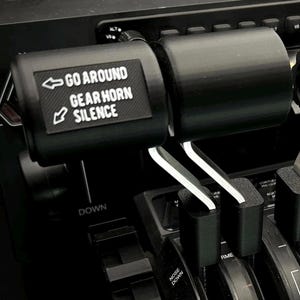May include: Black throttle quadrant add-on with the text "GO AROUND GEAR HORN SILENCE". The add-on is designed for flight simulation. The image shows the throttle levers and related controls.