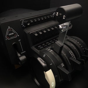 May include: A black aircraft control panel with multiple switches, knobs, and dials. The panel features a gear lever, a throttle lever, and a trim wheel. The panel is labeled with the words "GEAR", "UP", "DOWN", "TRIM", and "FLIGHT CONTROL".
