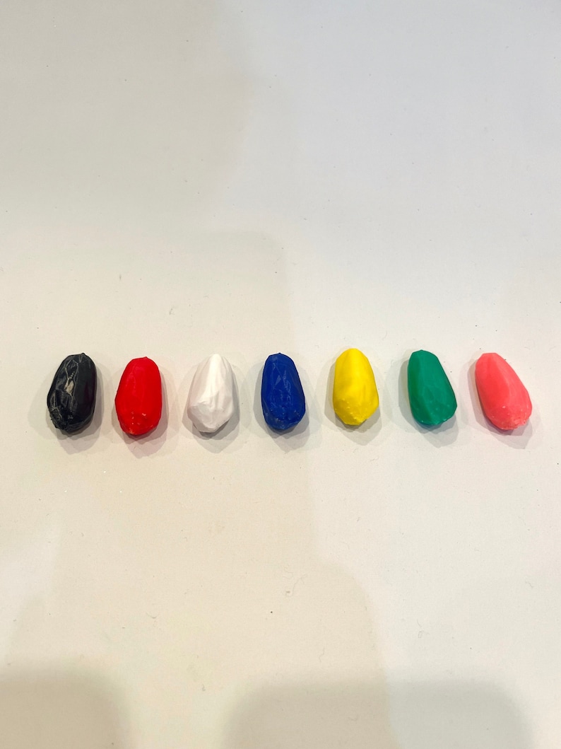 K&ouml;nnte beinhalten: Sieben kleine, eif&ouml;rmige St&uuml;cke Ton in verschiedenen Farben: Schwarz, Rot, Wei&szlig;, Blau, Gelb, Gr&uuml;n und Rosa.