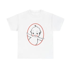 Peut inclure: Un t-shirt blanc à manches courtes arborant un motif central représentant un bébé de dessin animé aux joues roses, entouré d'un fin ovale rouge. Le bébé a une petite mèche de cheveux et les bras écartés, dans un style de trait noir simple.