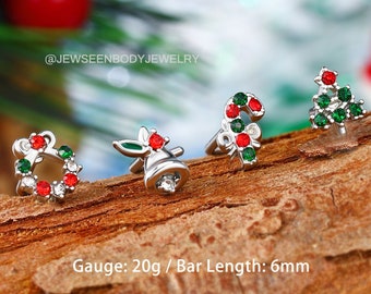 May include: Four silver Christmas themed body jewelry pieces with red and green gems. The pieces are a wreath, a bell, a candy cane, and a Christmas tree. Gauge: 20g / Bar Length: 6mm