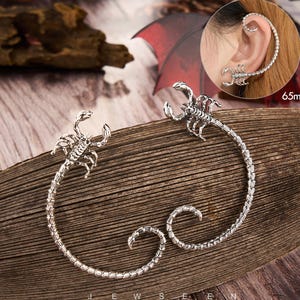 May include: Silver-toned scorpion ear cuff jewelry. The cuff wraps around the ear and features a detailed scorpion design. The ear cuff is approximately 65mm in length.