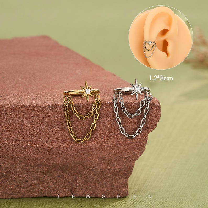 May include: Gold and silver ear cuffs with starburst and chain details. The ear cuffs are displayed on a brown surface. The text "JEWSEN" is visible at the bottom of the image. The ear cuffs measure 1.2mm x 8mm.