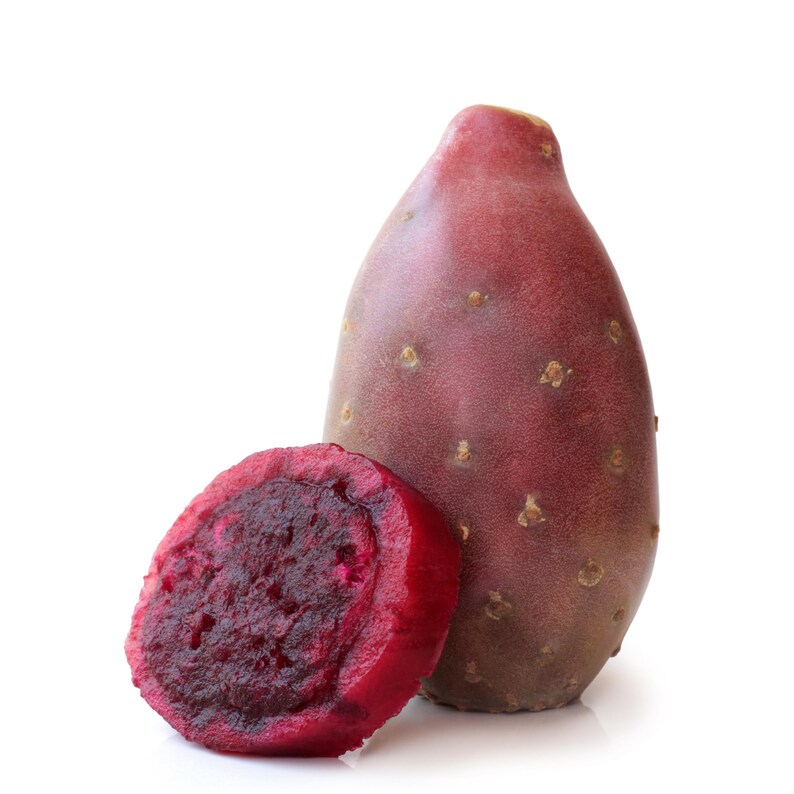May include: A whole and a sliced prickly pear fruit against a white background. The whole fruit is a deep red-purple color with small brown spots. The sliced fruit reveals a vibrant red interior. The fruit is a popular ingredient in many recipes.