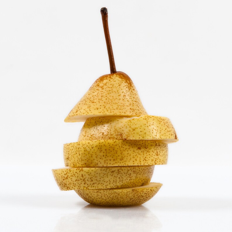 May include: A sliced pear, stacked to show the fruit's interior. The pear is yellow with brown speckles and a brown stem. The slices are arranged to maintain the pear's original shape, showcasing a fresh, healthy food item.