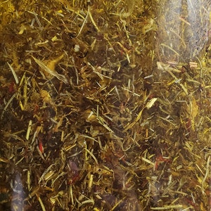 Puede incluir: Un frasco de vidrio lleno de hierbas y flores secas, sumergidas en un l&iacute;quido transparente. Las hierbas y las flores son una mezcla de verde, amarillo y rojo.