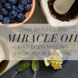 May include: A close-up of ingredients for a Brazilian miracle oil. The ingredients include a bowl of dark blue berries, a mortar and pestle with cloves, a small dish of white butter, and a yellow flower on a blue dish.