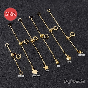 May include: Gold necklace extenders with different charms, such as a heart, star, and ball. Each extender has a fine chain and a clasp for easy attachment. The image includes the text "G18K".